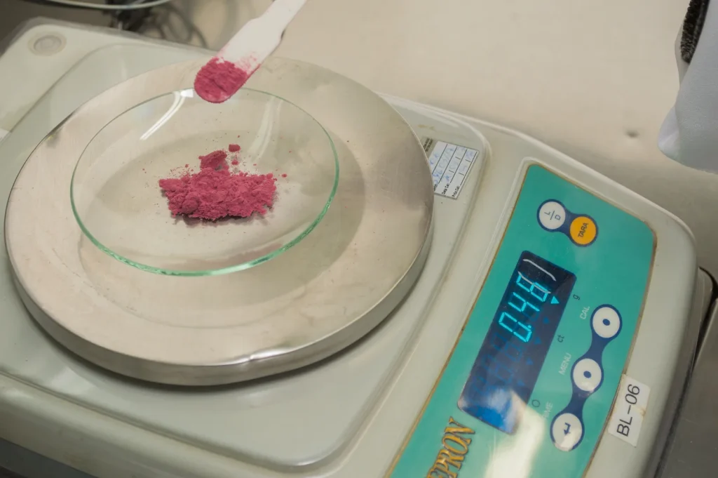 Pesagem de matéria-prima em balança de precisão no laboratório da Poção Mágica