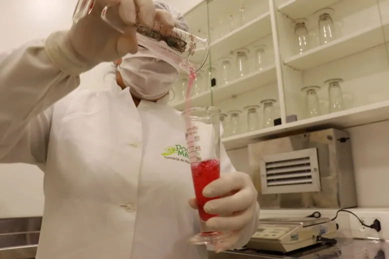 Farmacêutica preparando uma fórmula líquida no laboratório da Poção Mágica